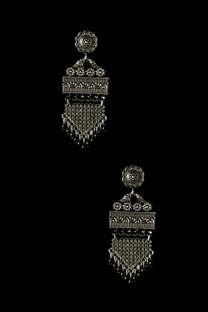 silver earrings arranged in two layers with blach background