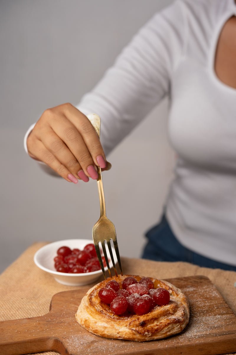 a girl eating pancake topped with cherries