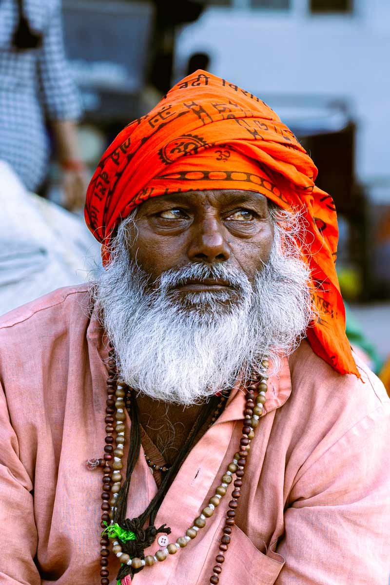 sadhu sitting with orange cloth on his head