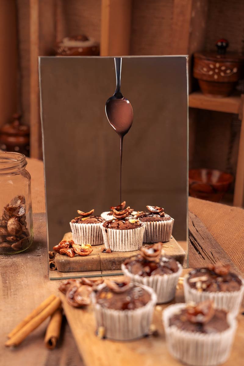 chocolate cupcakes drizzled with chocolate sauce seen in mirror reflection