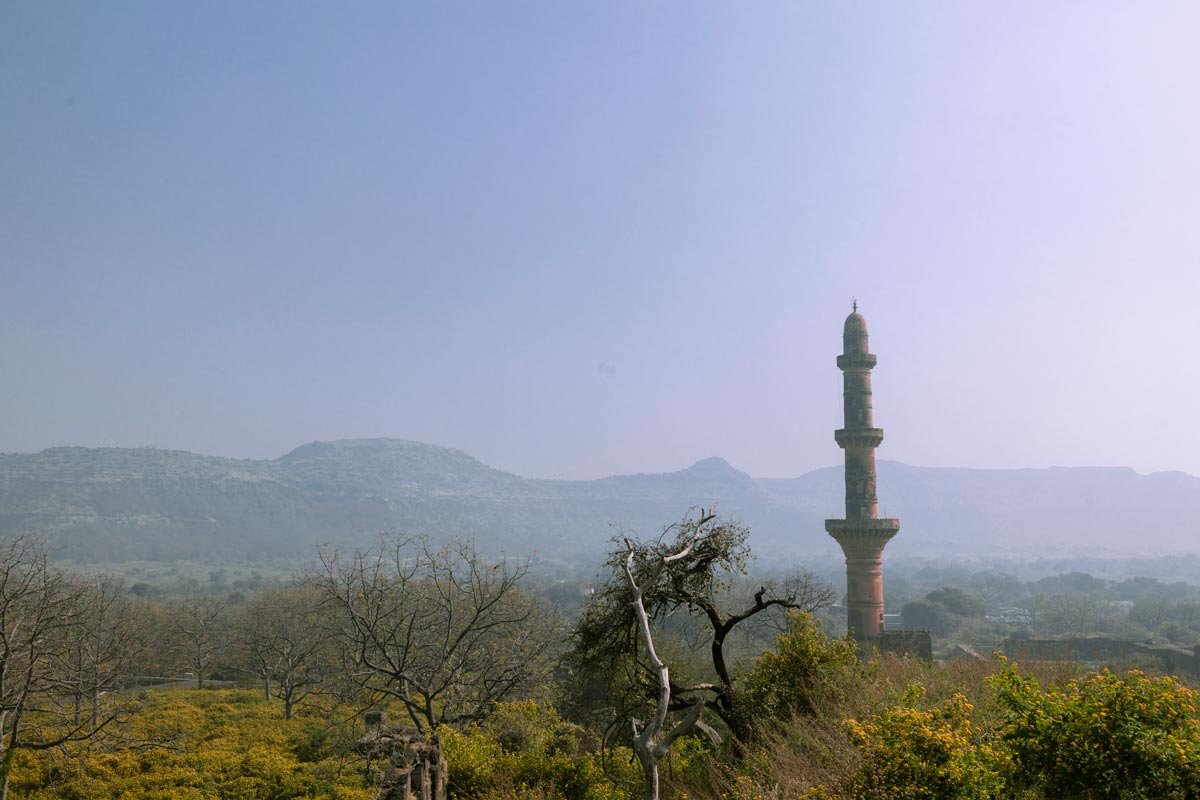 the minar with mountain and tress