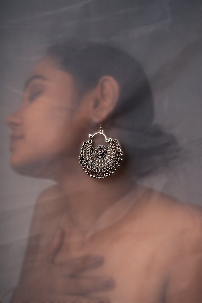 a girl with big silver ear ring