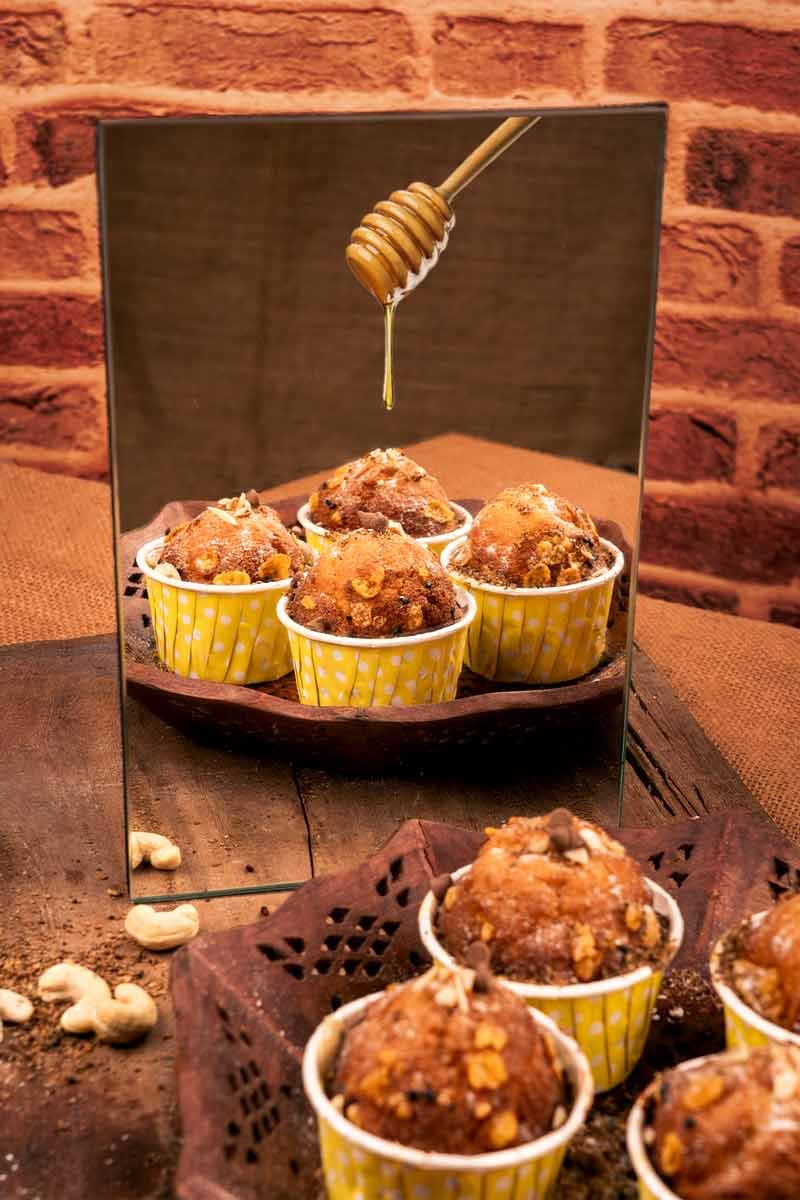 fluffy muffins drizzled with honey on top seen in mirror reflection