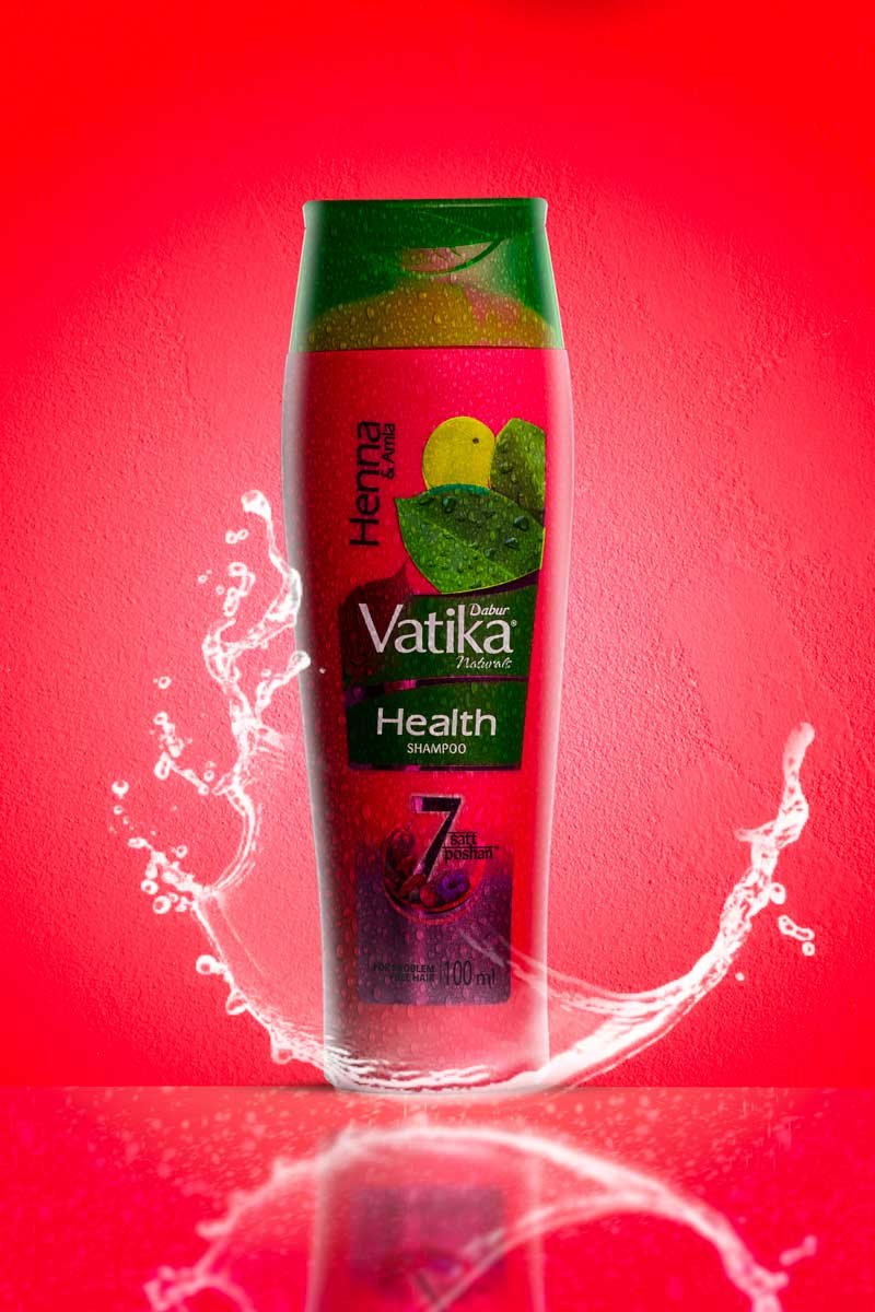vatika shampoo with water splash in red background