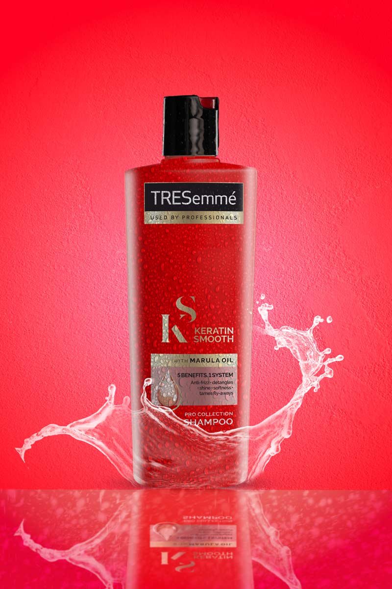 Tresemme shampoo with water splash in red background