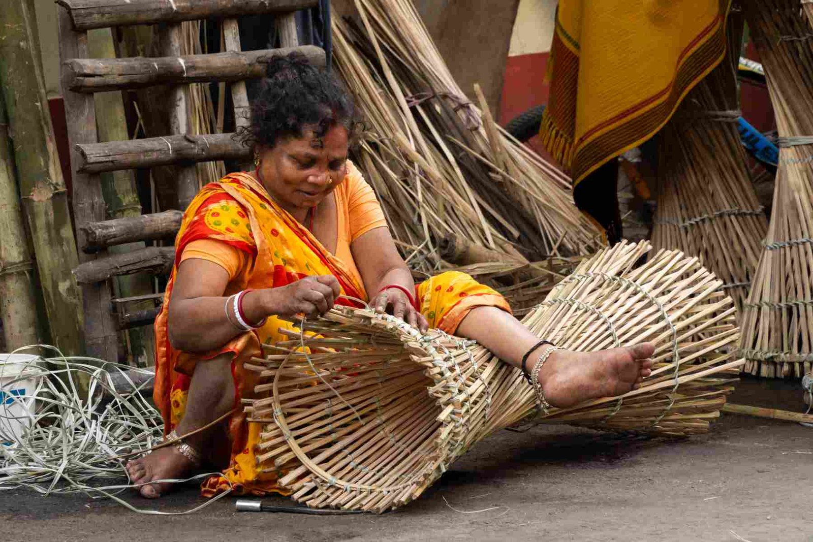 lady doing cane craft from nearby the roadside