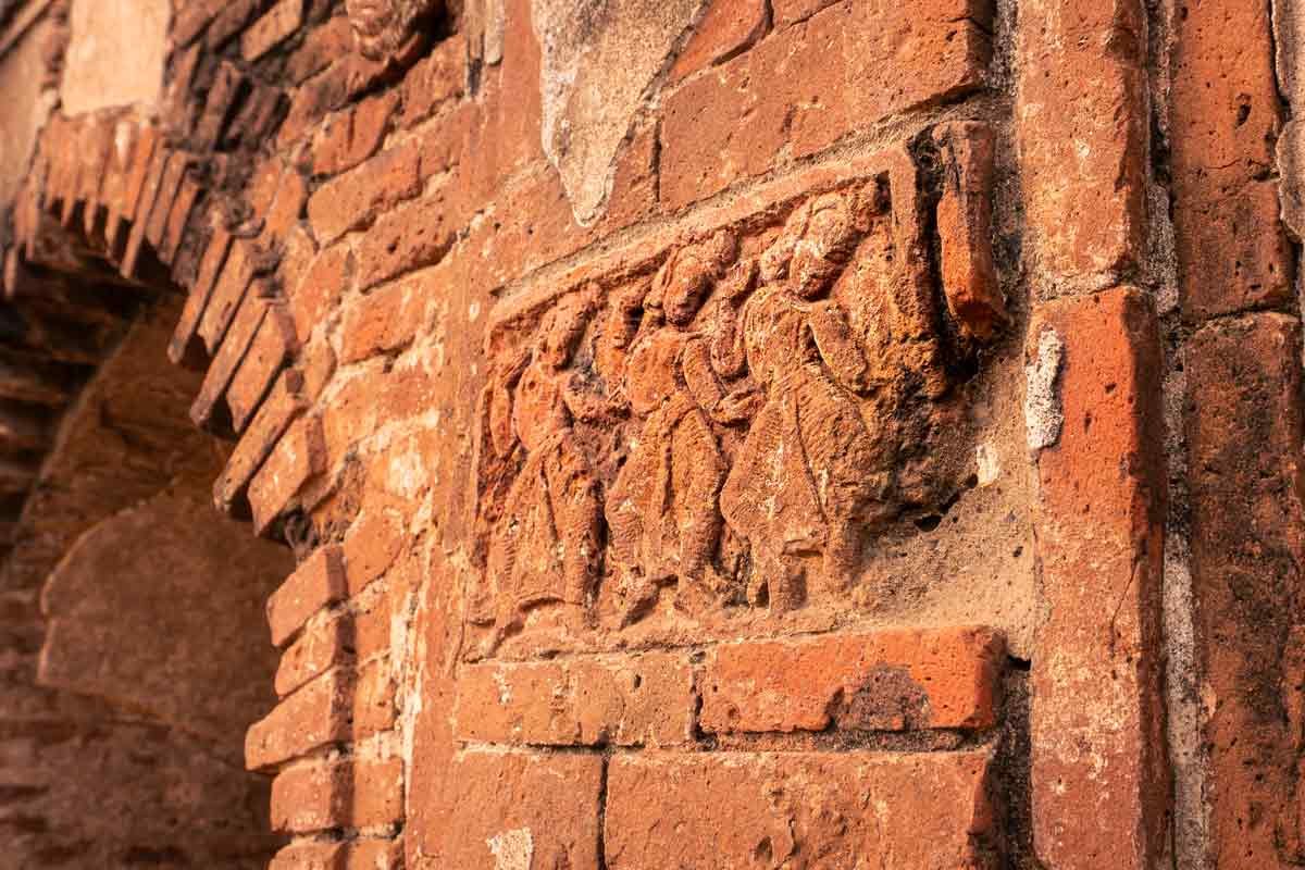 dancing sculptures carved on a terracotta wall