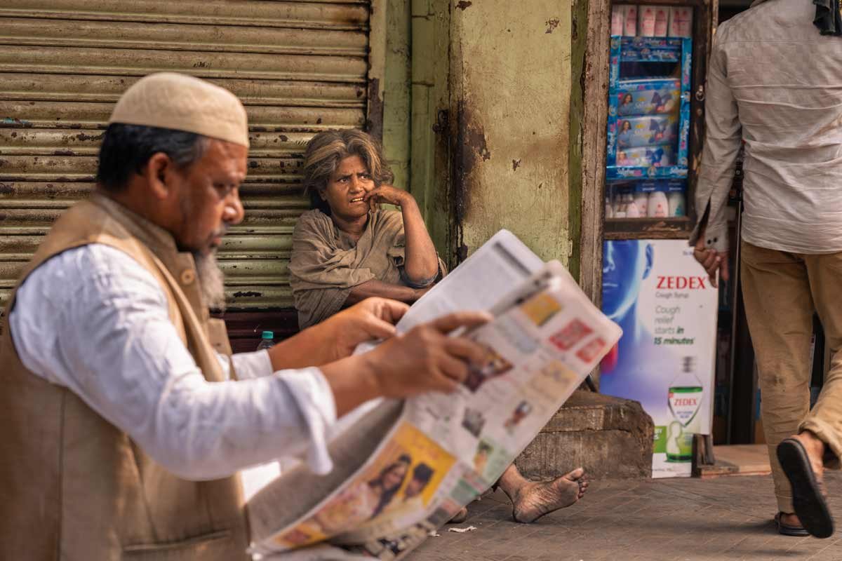 a woman thinking and a man reading newspaper