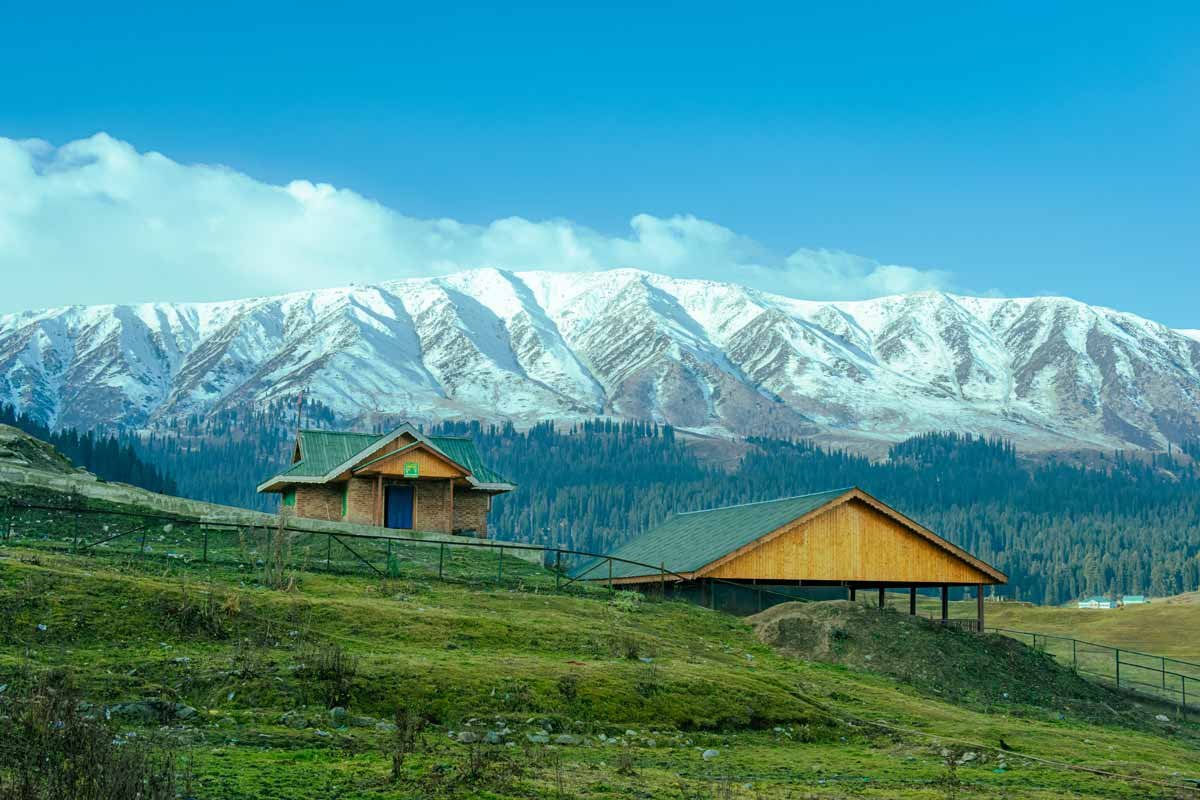 two hut houses with the landscape of mountains
