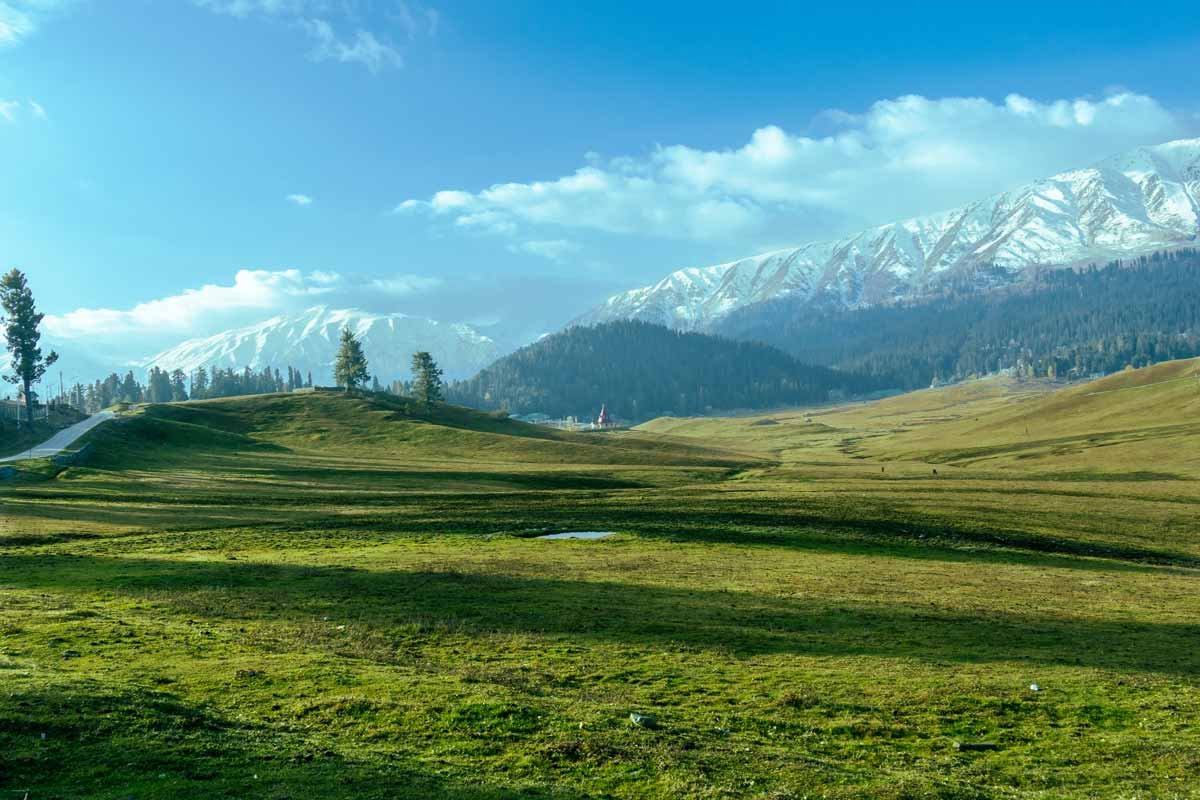 A photo inwhere you can see mountains topped with snow and green land