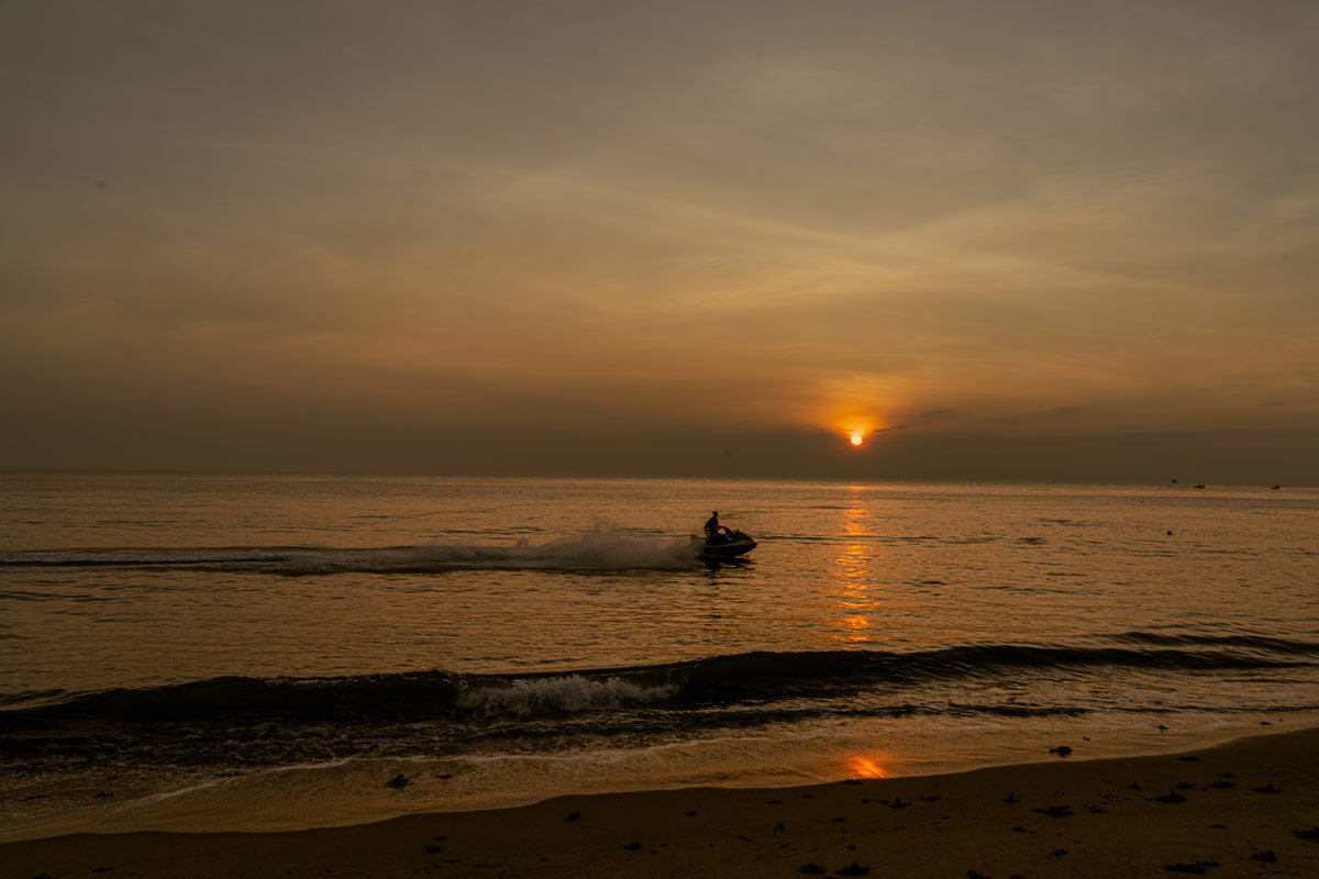 a boy is travelling in speed boat in sunset time