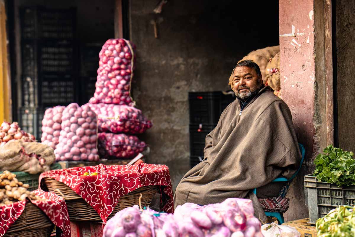 a old man sitting near his vegetable market