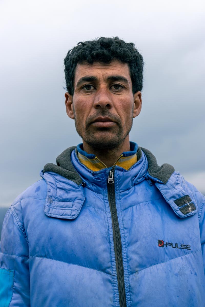 a man looking chilled while wearing a blue jacket