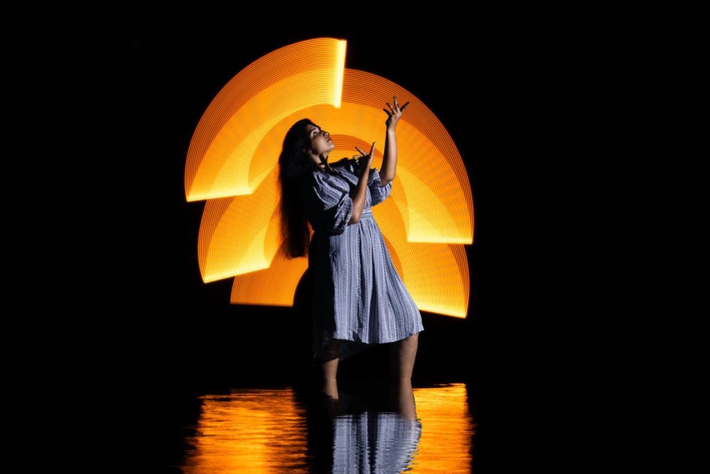 Creative embrace of a young woman portrayed through light painting