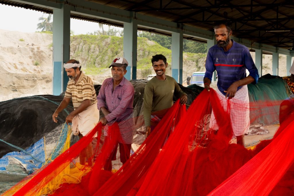 Workers working together to wrap fishing nets.