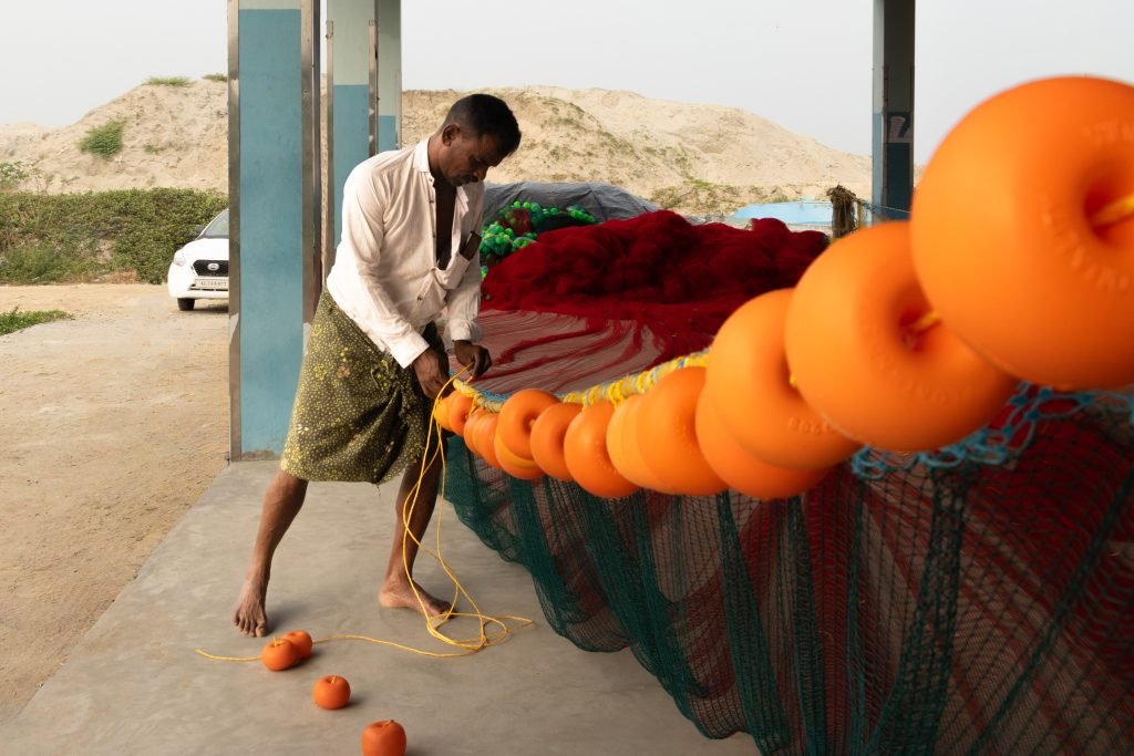 A man weaving floats into fishing nets.