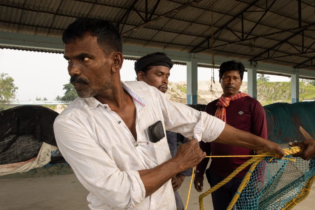 A man pulling the rope to tighten the knots.