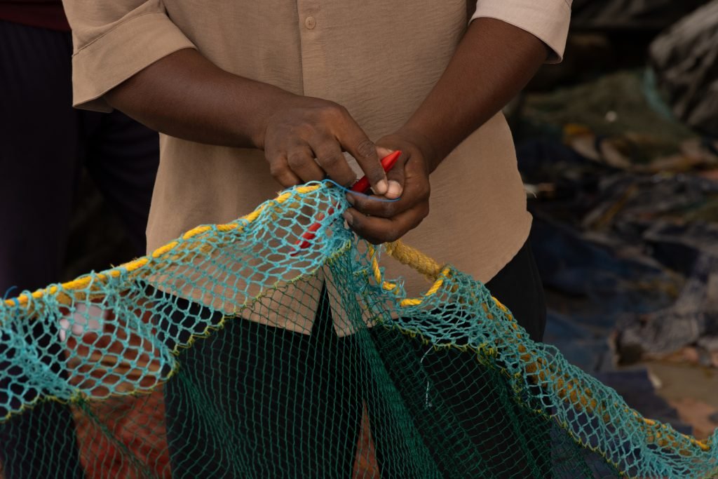 A worker knitting the fishing net.
