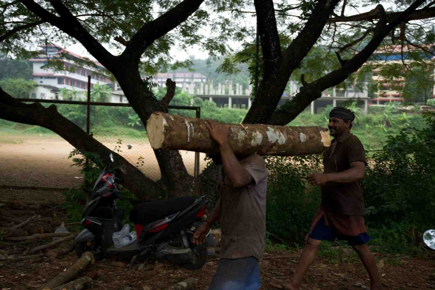 one person taking and going the log, and back of him, one person is with a head-covered towel.