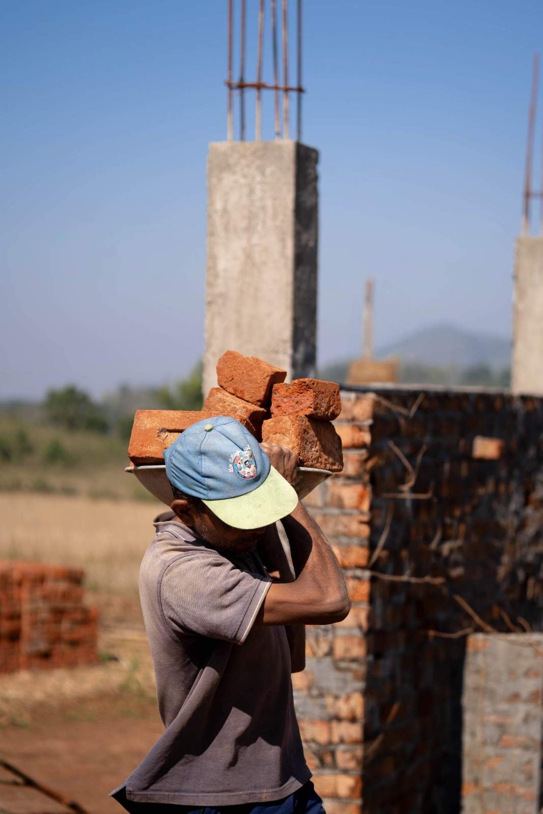 a man is carrying red bricks