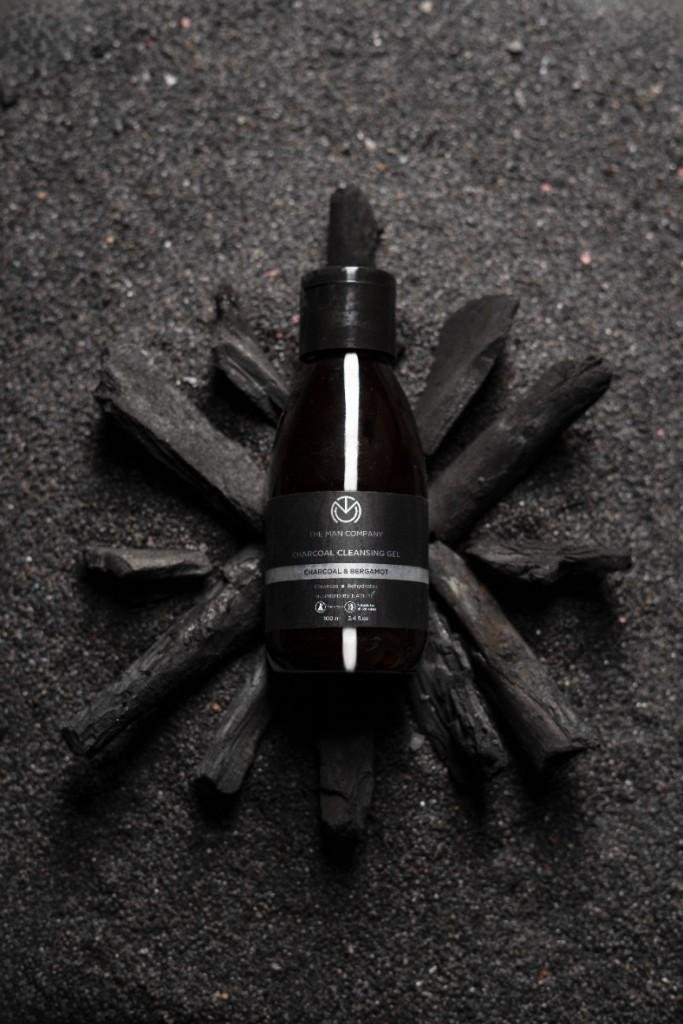 A cosmetic bottle on charcoal.