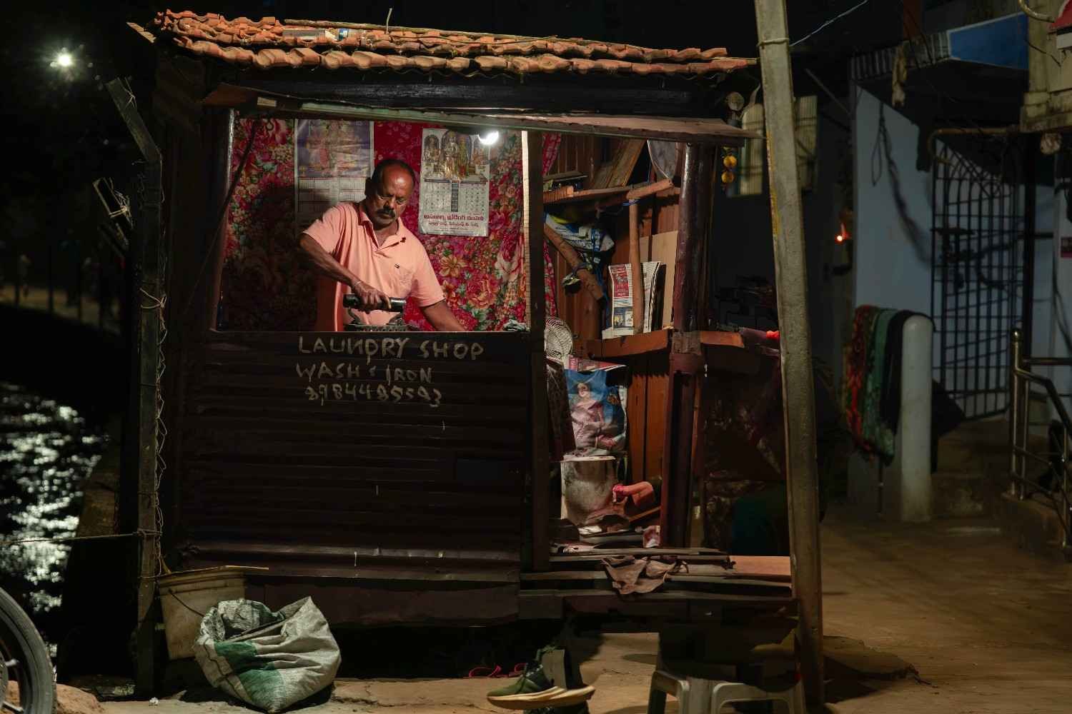 a old man was ironing the cloths in the night