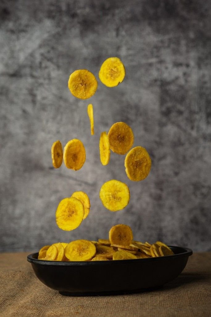 Banana chips dropping in a bowl.