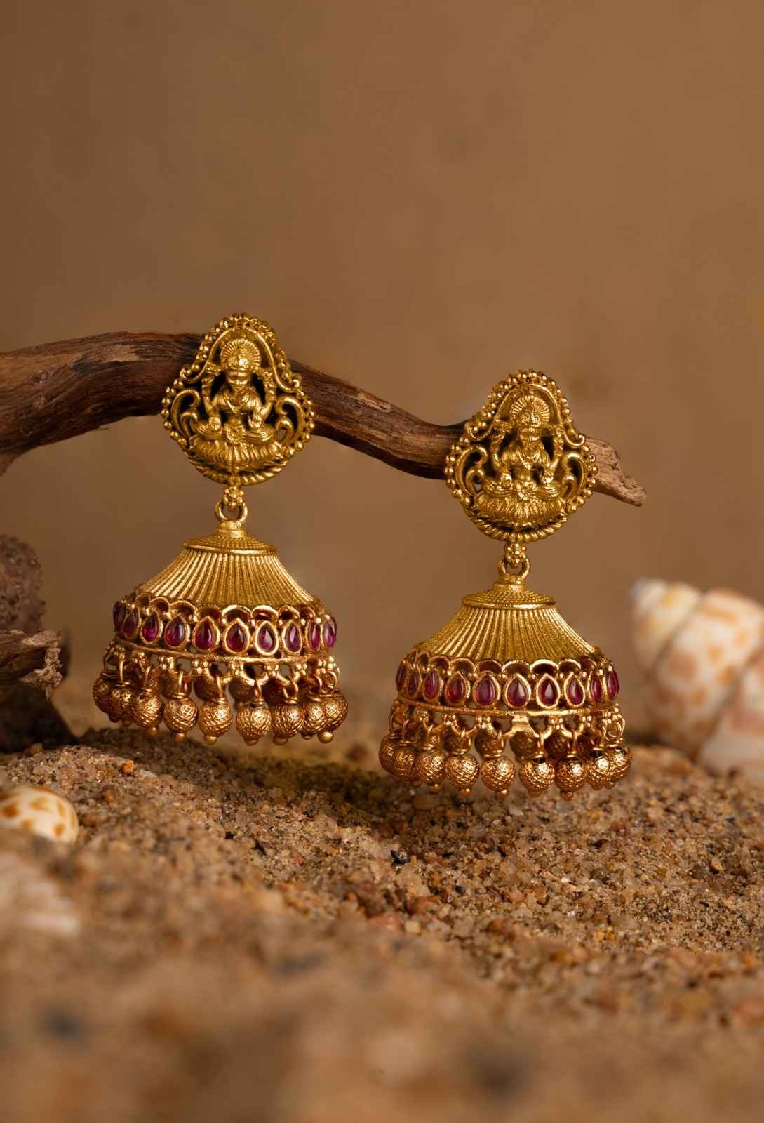 golden earrings hanging on the sticks