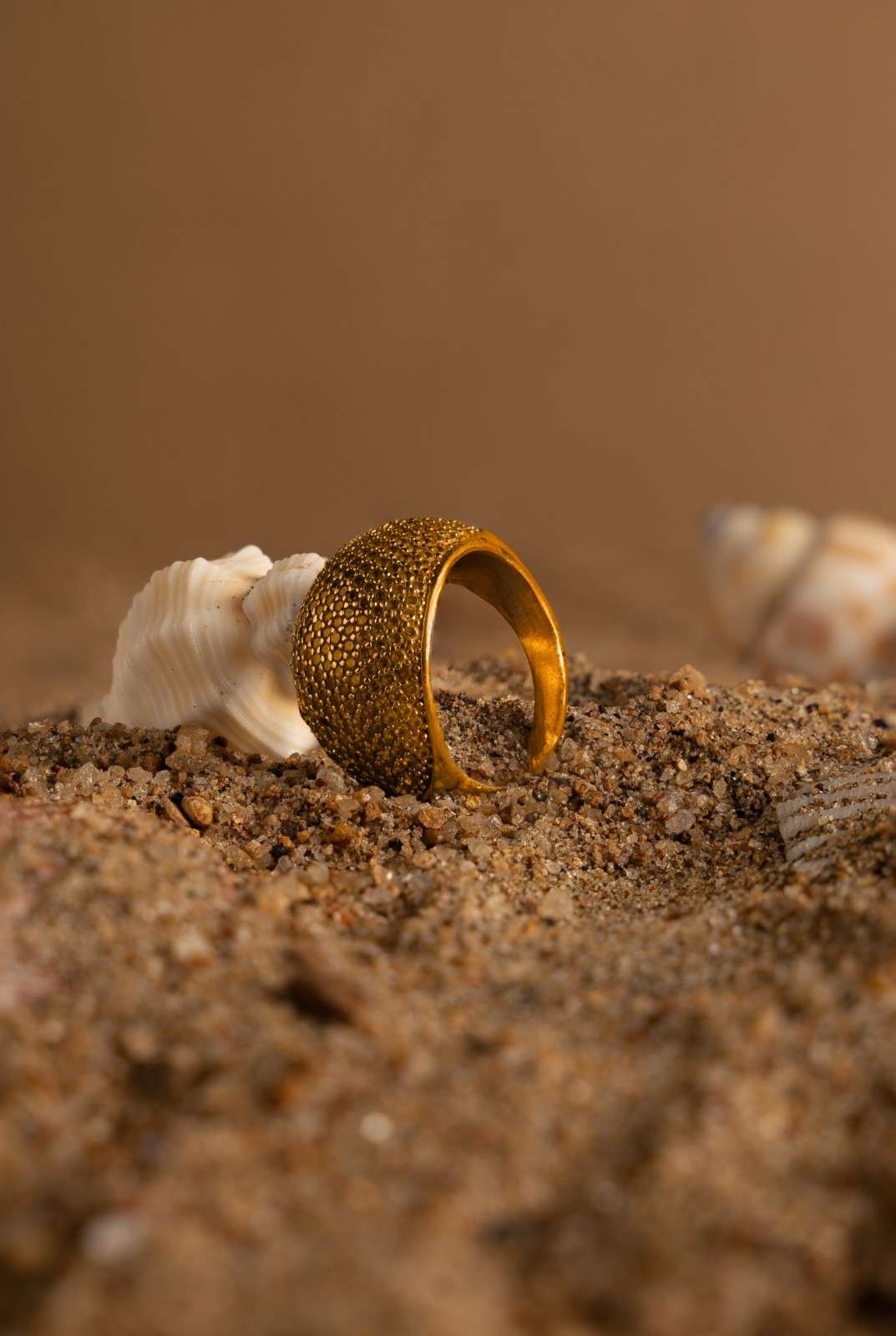 A golden ring placed in the sand