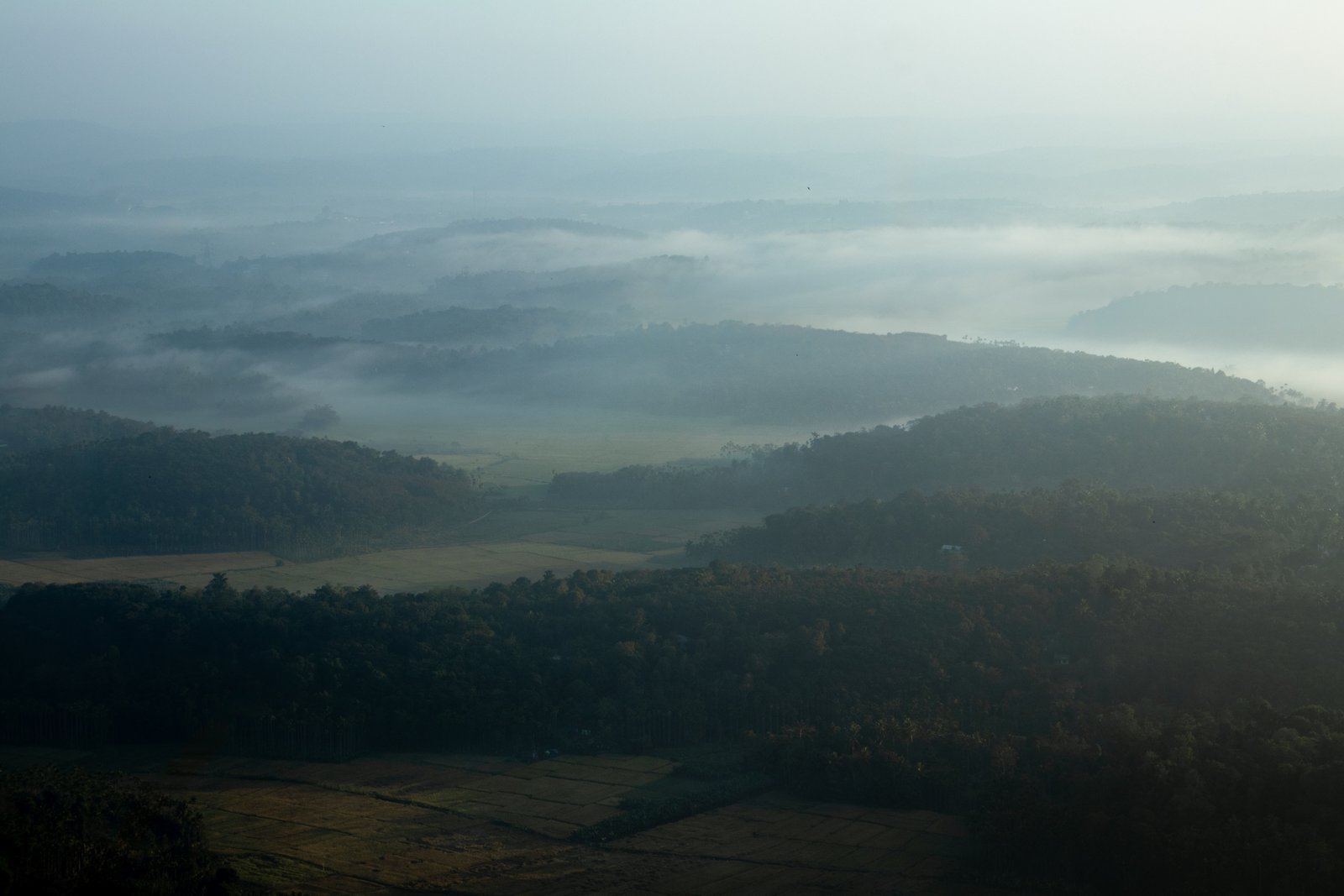 Soft mists covering mountains in the early morning.