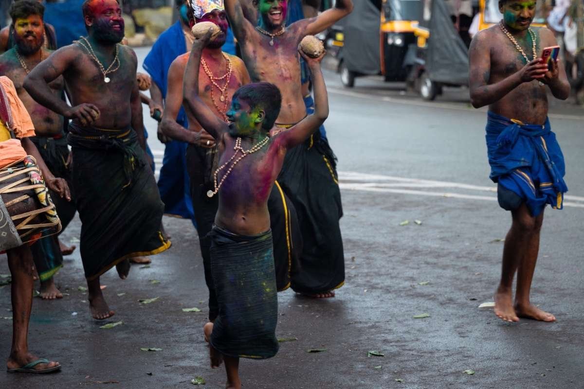 a boy dancing in Petta Thullal with holding coconuts