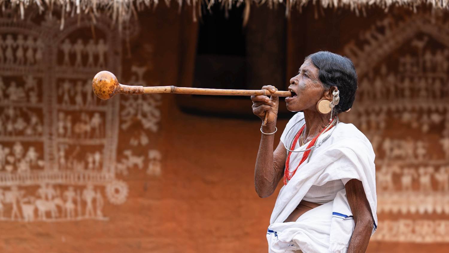 Tribal woman sipping alcohol.