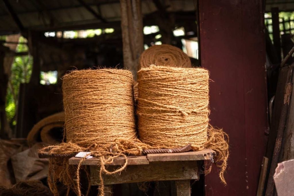 Spools of coir rope on a wooden shelf.