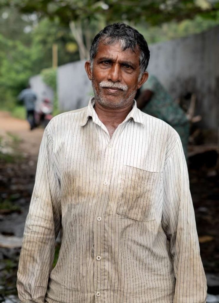 Resilient A man with a weathered face in a striped shirt.