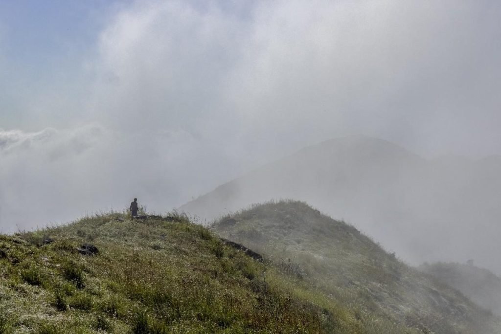 Cloddy capped mountains hide its face
