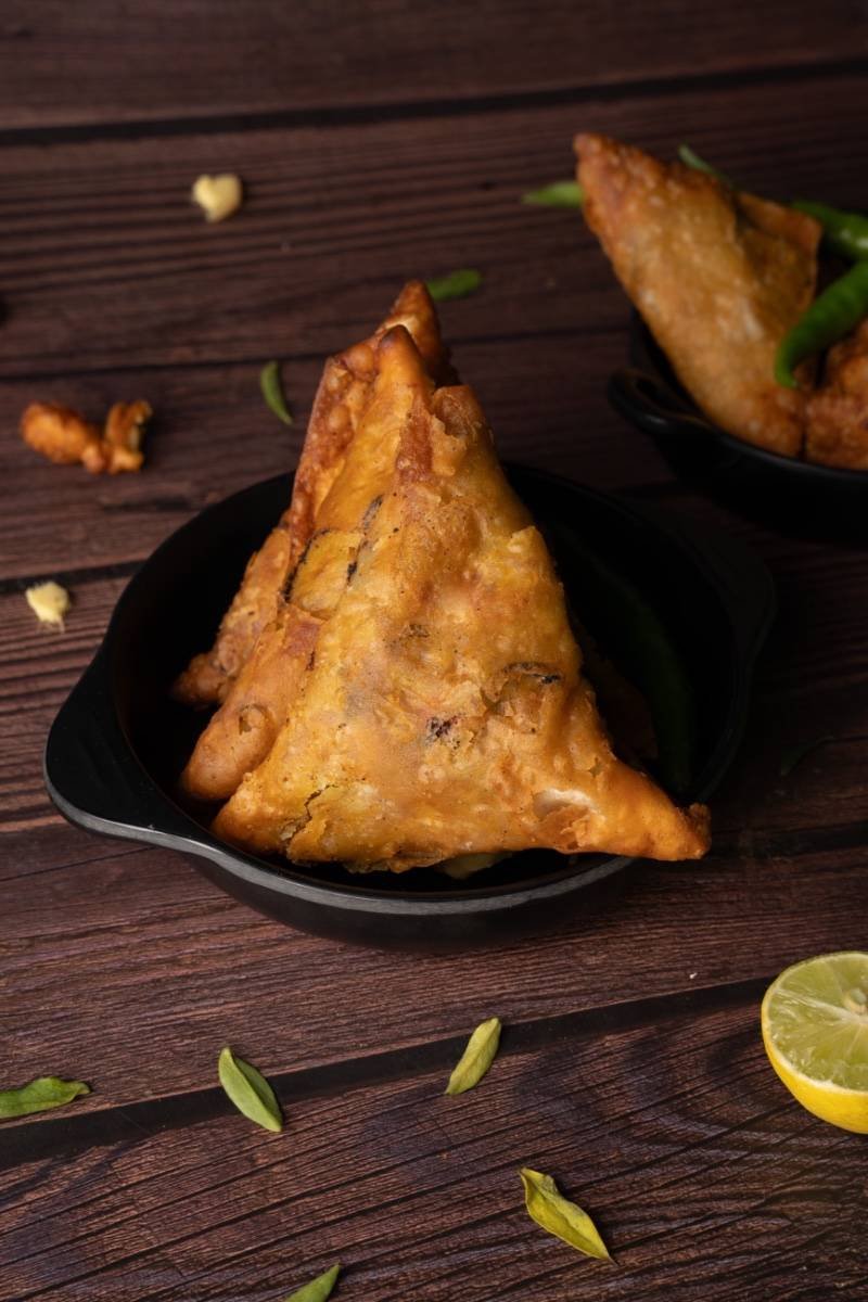 samosas paired with fresh lemon and chilies.