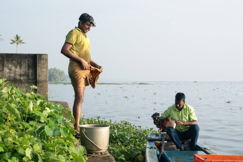 Morning Catch Exchange A fisherman and a buyer exchange words at the backwater shore.
