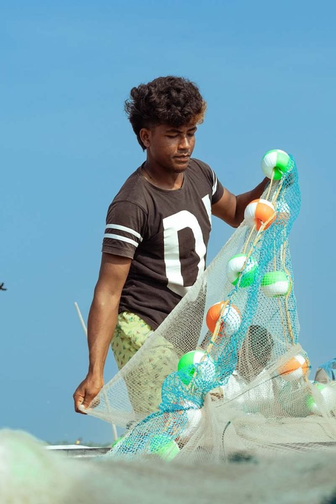 Young fisherman mending nets.