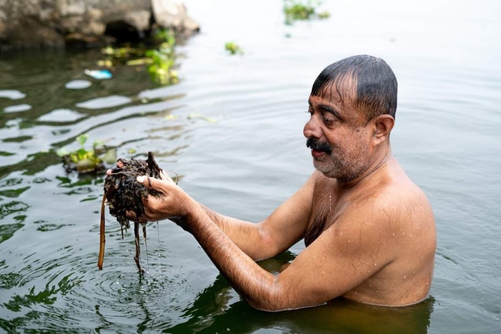Childlike Joy Man bathing in Alappuzha backwaters at sunrise.