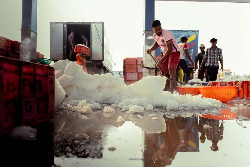 A man shoveling the ice pieces.