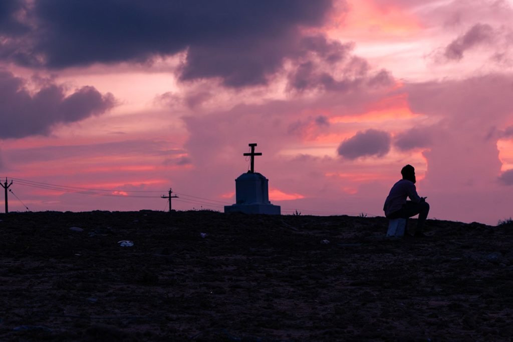 Silent Contemplation A man sitting by the holy cross relic.