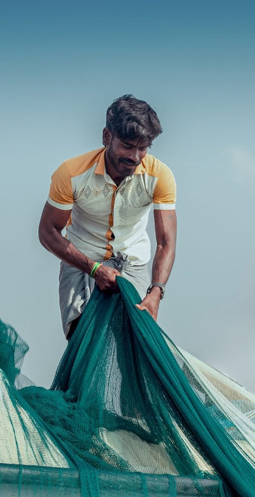silent strength, a fisherman mending nets.